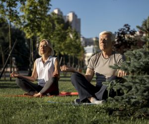 casal-de-idosos-praticando-ioga-ao-ar-livre