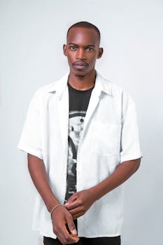 A cool and contemporary portrait of a young man wearing a stylish white shirt and black graphic tee.